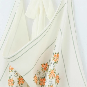 Floral halter top with orange roses and green stripes on milky white satin fabric