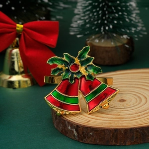 Detail of a festive gold Christmas napkin ring featuring red and green bells and holly leaves