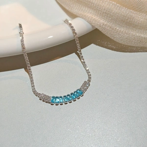 Macro shot of silver bracelet featuring eight blue emerald-cut crystals and pavé detail