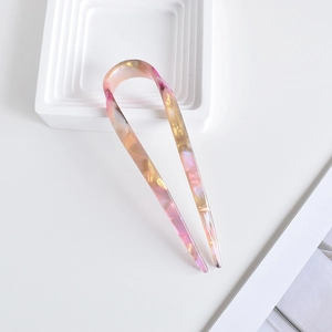 Detailed close-up of U-shaped acetate hair pin with stylish tortoiseshell pattern and texture