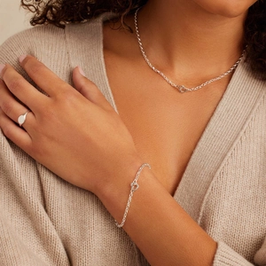 Close-up of heart paperclip necklace and bracelet set in silver stainless steel on model