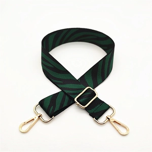 Detail of green and black zebra pattern bag strap with polished gold hardware
