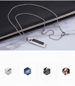 Close-up of a square stainless steel pendant with black grid inlay and cubic zirconia