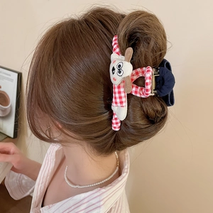 Détail d'une grande pince à cheveux en tissu vichy rouge et blanc avec chien en peluche