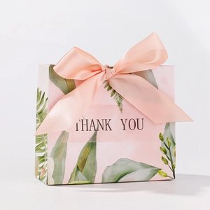Pink wedding favor box with green leaf patterns and a silk ribbon bow, with Thank You text