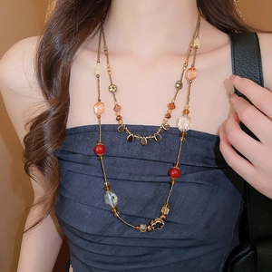 Vue détaillée du collier à perles double épaisseur avec facettes orange et pendentif cristal