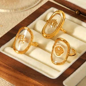Detailed macro view of gold-plated sea shell, starfish, and sun resin inlay rings