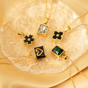 Elegant gold necklaces with assorted gemstone pendants on a textured glass tray