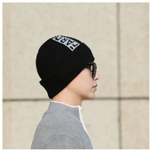 Detail of black ribbed knit beanie featuring white FARD letter jacquard and fold-over cuff