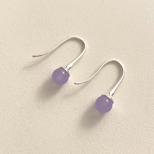 Detailed macro view of 925 sterling silver hook earrings with translucent purple agate beads