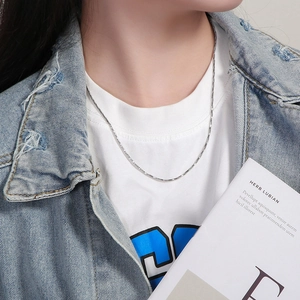 Detailed view of silver snake chain necklace worn on model for casual styling