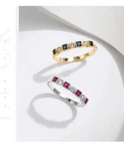 Detail of stacked s925 silver rings with colorful gems and round zircons on stone decor