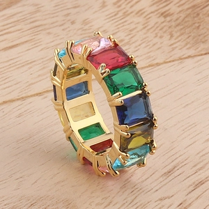 Micro-set colorful rectangular zircon rainbow ring with golden finish on wood background