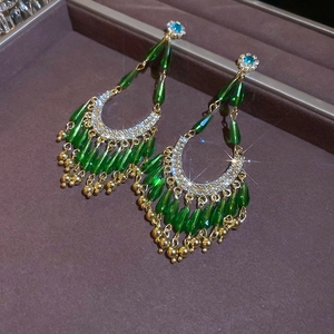 Détail de boucles d'oreilles fleurs et gouttes vertes sur un coffret à bijoux
