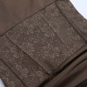 Close-up of intricate lace floral embroidery and brown knit fabric texture detail