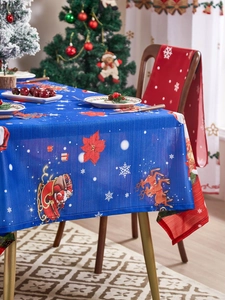 Detail of Christmas tablecloth with Santa and reindeer pattern in festive dining setting