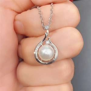 Close-up of a Baroque pearl pendant with sparkling zircon accents on a silver chain