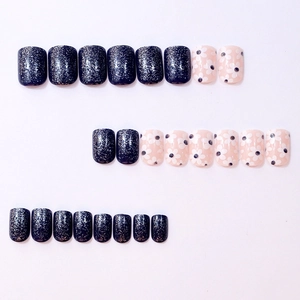 Short square press-on nails with blue glitter and daisy floral patterns on white background