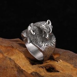 Macro shot of retro silver double wolf head ring displayed on natural wood base