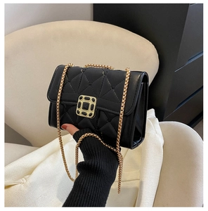 Close-up of black quilted leather handbag with gold chain strap and vintage square buckle