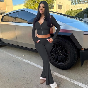 Detail of black long-sleeve zip hoodie and high-waist flared pants set in a modern look