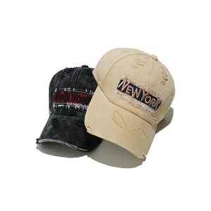 Detail of vintage washed cotton baseball caps with New York embroidery and distressed edges