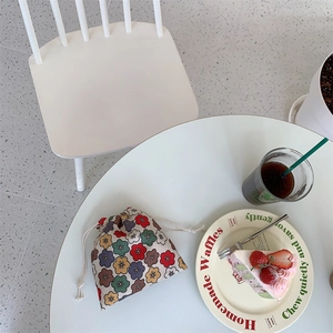 Floral cotton linen drawstring bag on a tea table with cake and coffee setup