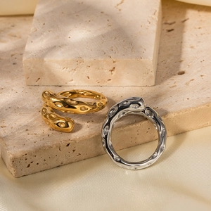 Details der unregelmäßigen Hammerschlag-Textur auf goldenen und silbernen Metallringen