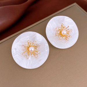 Gros plan détaillé d'une boucle d'oreille ronde vintage en perles et zircons sur soie