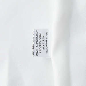 Étiquette d'entretien sur robe en dentelle blanche avec instructions de lavage