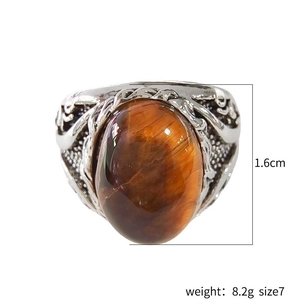 Men's vintage silver ring featuring a large oval tiger eye stone on a plain background