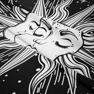 Close-up of black and white bohemian tapestry fabric showing celestial sun and moon patterns