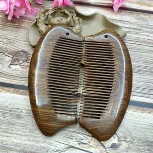 Classic 13cm black sandalwood comb with double-sided fine teeth on a natural wood surface