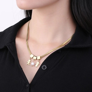 Detail of gold flat snake chain with cartoon boy girl charms and a single pearl