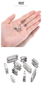 Macro display of assorted stainless steel jewelry clasps shown in hand for scale