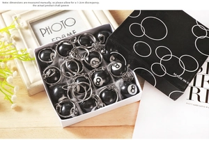 Detail of resin number 8 billiard ball keychains in a white presentation box