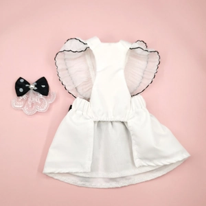 White pet wedding dress with black scalloped edges and pearl bow on pink background