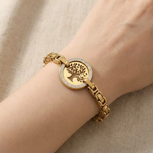 Detail of gold life tree bracelet with white zircons on chunky chain worn by model
