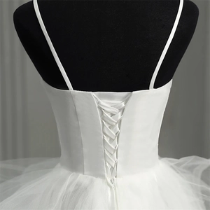 Close-up of elegant corset back with adjustable lace-up ties on white tulle bridal dress