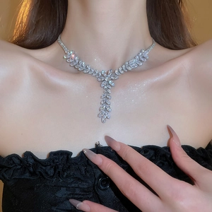 Detail showing a silver wheat ear tassel necklace with sparkling zircons on a model