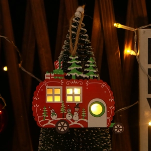Close-up of red wooden Christmas RV ornament with glowing LED lights and snowman detail
