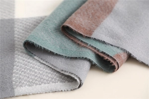 Close-up of the thick plaid cashmere texture and detailed stitching on the folded scarf