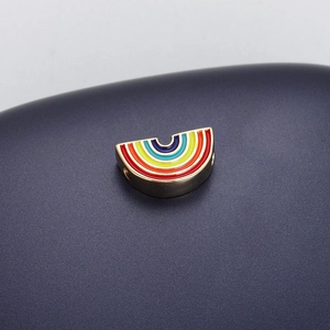 Macro shot of a golden rainbow charm with colorful enamel inlay for DIY jewelry making