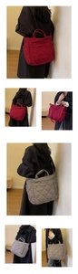 Detail view of red and grey quilted nylon tote bags with top handles and shoulder straps