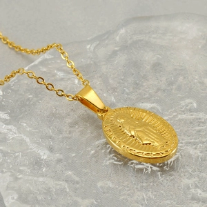 Close-up of golden Saint Maria medallion pendant on a textured ice-like background