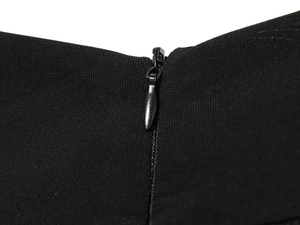 Detalle de cremallera invisible en mono negro de punto con tirador metálico elegante