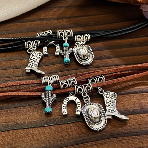 Detail of Western style jewelry with silver bull head, cowboy boots and lucky horseshoe