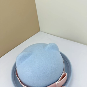 Close-up of cute cat ears and pink bow detail on blue wool felt JK sailor hat