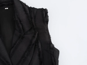 Détails de la robe blazer sans manches noire montrant la texture tissée et bords effilés