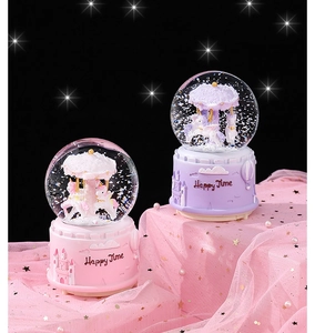 Detail view of pink and purple carousel music boxes with shimmering glitter and dream-like lights